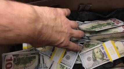 Young Man Handles Cash In Suitcase