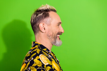 Stylish mature man in a printed summer shirt smiling and enjoying a cheerful moment with a vibrant...