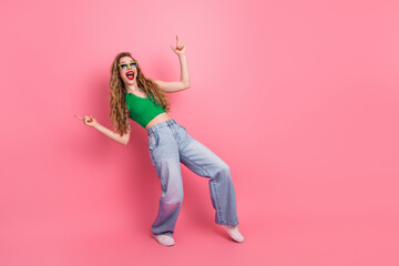 Young stylish woman in casual outfit with long blonde hair smiling on pink background, expressing...