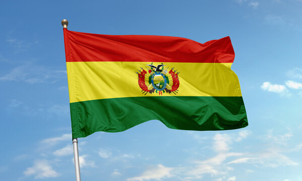 Bolivia national flag with red, yellow, and green horizontal stripes and detailed coat of arms waving in the sky
