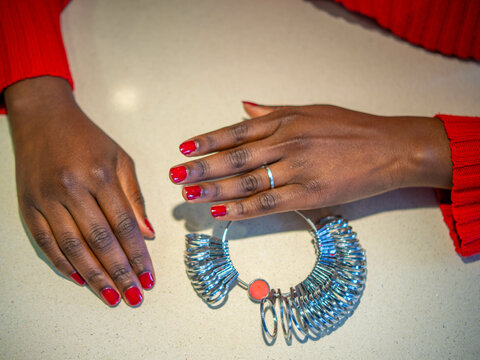Woman's hand choosing the correct ring size with a ring sizer.