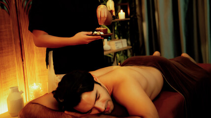 Man customer having exfoliation treatment in luxury spa salon with warmth candle light ambient....
