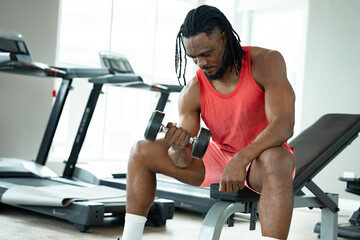 Fototapeta premium African man exercise with dumbbell at fitness gym 