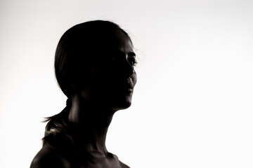 Silhouette of a young woman in a studio setting, low key lighting portrait