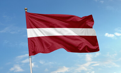 Latvia national flag waving in wind against clear blue sky