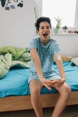 Teenager girl waking up and stretching in bed in the morning