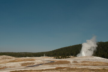 Old Faithful Geyser erupting during the day time in yellowstone national park