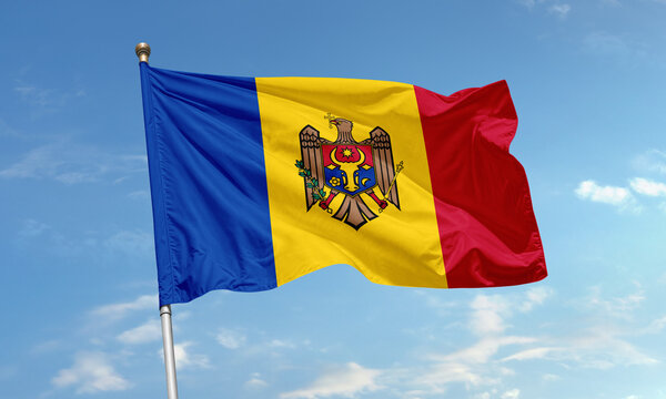 Moldovan national flag with blue, yellow, red stripes and coat of arms waving in sky