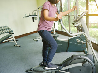 Woman working out on elliptical cross trainer exercise machine