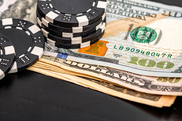 Stacks of poker chips with money on black background
