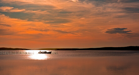 The last ray of light over the boat at sunset in the Albufera, Valencia, Spain
