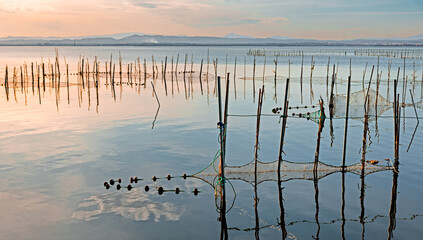 Fishing nets at sunset in the calm waters of the Albufera lagoon, Valencia, Spain