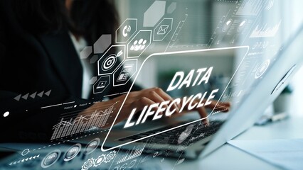 Business professional working on laptop with data lifecycle graphics in modern office environment showcasing technology and analytics. Asymptotic smart data analytic.