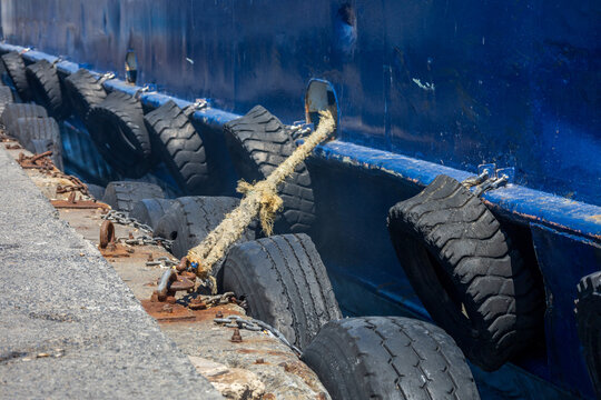 Close-up of mooring rope and rubber fenders securing ship to rusty dock in Istanbul harbor