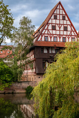 Nuremberg, Germany, August 2, 2023. Beautiful shot with an iconic image of the fairytale atmosphere of the place. On the beautiful summer day the half-timbered house is reflected in the water.