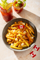 Traditional Canadian poutine with fries, cheese curds, and gravy, decorated with Canadian flag.