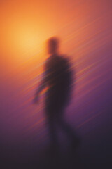 Fototapeta premium Abstract Blurred Figure Walking Through Orange and Purple Haze 