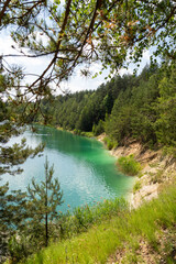 turquoise water lake surrounded by pine trees, top view.A beautiful summer day