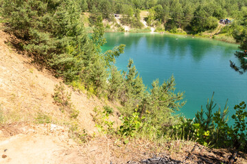 turquoise water lake surrounded by pine trees, top view.A beautiful summer day