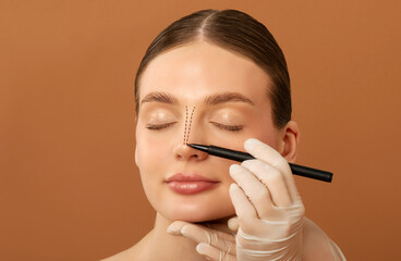 Rhinoplasty operation concept. Doctor making marks on female nose, young woman preparing for...