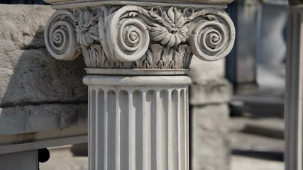 Detailed view of a decorative capital on a fluted column made of white stone or marble, architectural element in a historical style. - Powered by Adobe