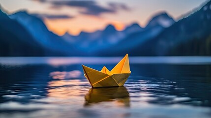 A origami boat floats on a lake at sunset.