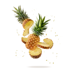 Fresh ripe tropical fruit pineapple and slices with juice drops flying isolated on yellow color background. © BarTa