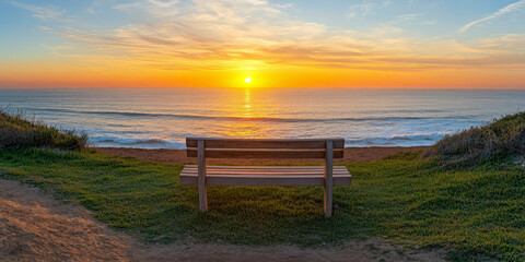 Obraz premium Wooden Bench Facing Ocean Sunset on Coastal Path