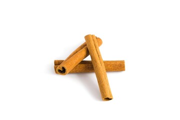 Neatly arranged cinnamon bark fragments on white, focusing on their coarse texture and natural...