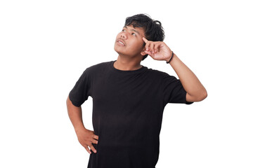 A young man in a black t-shirt stands against a white background, looking thoughtful with one hand...