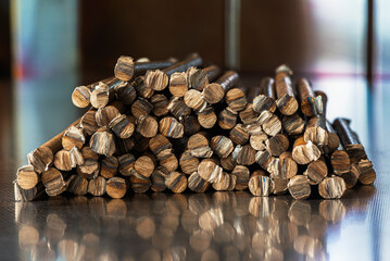 Stack of smooth steel rods on an industrial metal surface