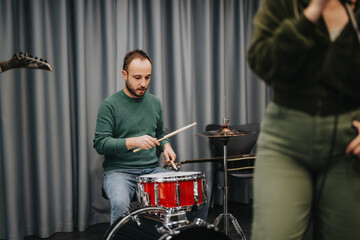 Band member practicing drums during a music rehearsal at a studio