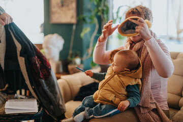 A mother interacts with her infant, holding them in their winter clothing, creating a warm and loving scene amidst a comfortable and cozy home interior.