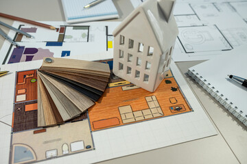 A detailed model house is elegantly positioned on top of an architects house plan design