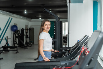 young caucasian woman running on a treadmill at gym