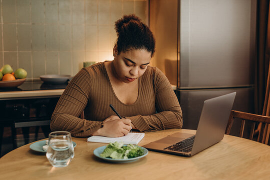 Woman makes notes about healthy diet and tips for inner confidence