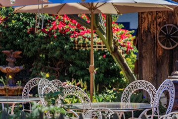 Empty rustic outdoor restaurant table, a patio with flowers, San Juan Capistrano