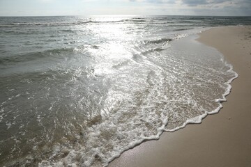 Sea waves rolling onto sandy tropical beach