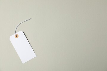 Blank tag with string on grey background, top view. Space for text
