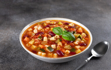 Italian vegetable soup minestrone on a dark background. Italian cuisine. Vegetarian food.