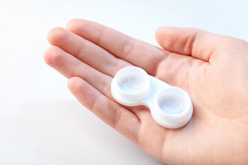 Woman with contact lenses on light background, closeup