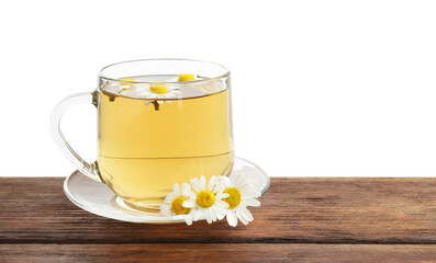 Delicious chamomile tea in glass cup and fresh flowers on wooden table against white background