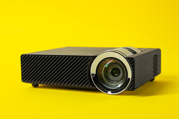 Modern video projector on yellow background, closeup