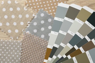Samples of colorful fabrics and color palettes on wooden table, flat lay