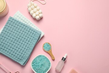 Clean waffle towels and cosmetic products on light pink background, flat lay. Space for text