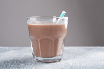 Tasty chocolate milk in glass on grey table, closeup
