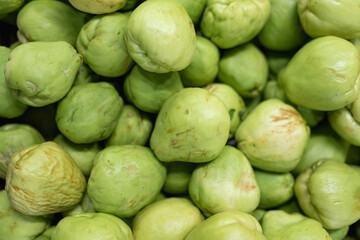 Pile of fresh green chayote squash at a local market