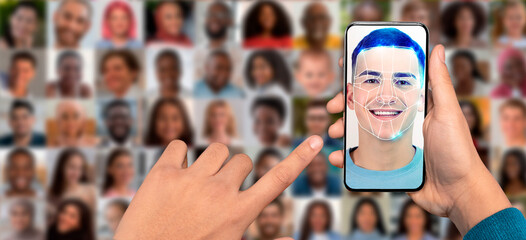 A person holds a smartphone displaying a facial recognition feature. The background features a...