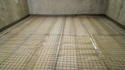 Waterproofing membrane and reinforcing mesh being installed on concrete floor