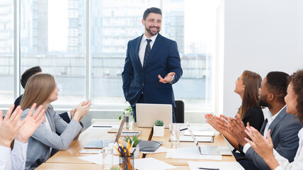 Business team congratulating successful male manager with applause after meeting